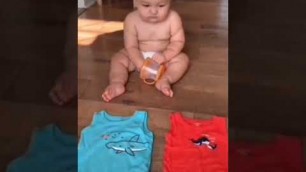 'Cute baby choosing his own clothes'